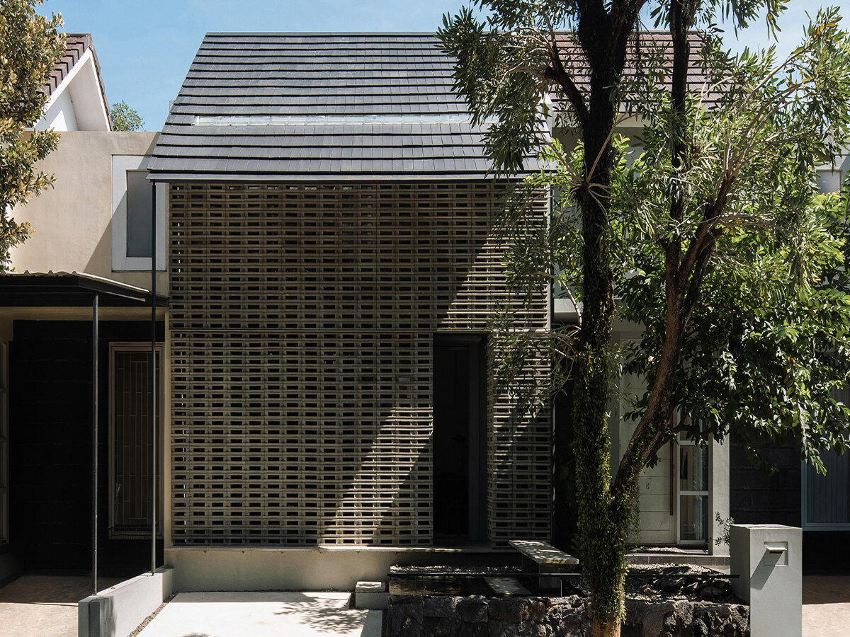 interlocking spaces behind perforated brick facade turn home into office in indonesia