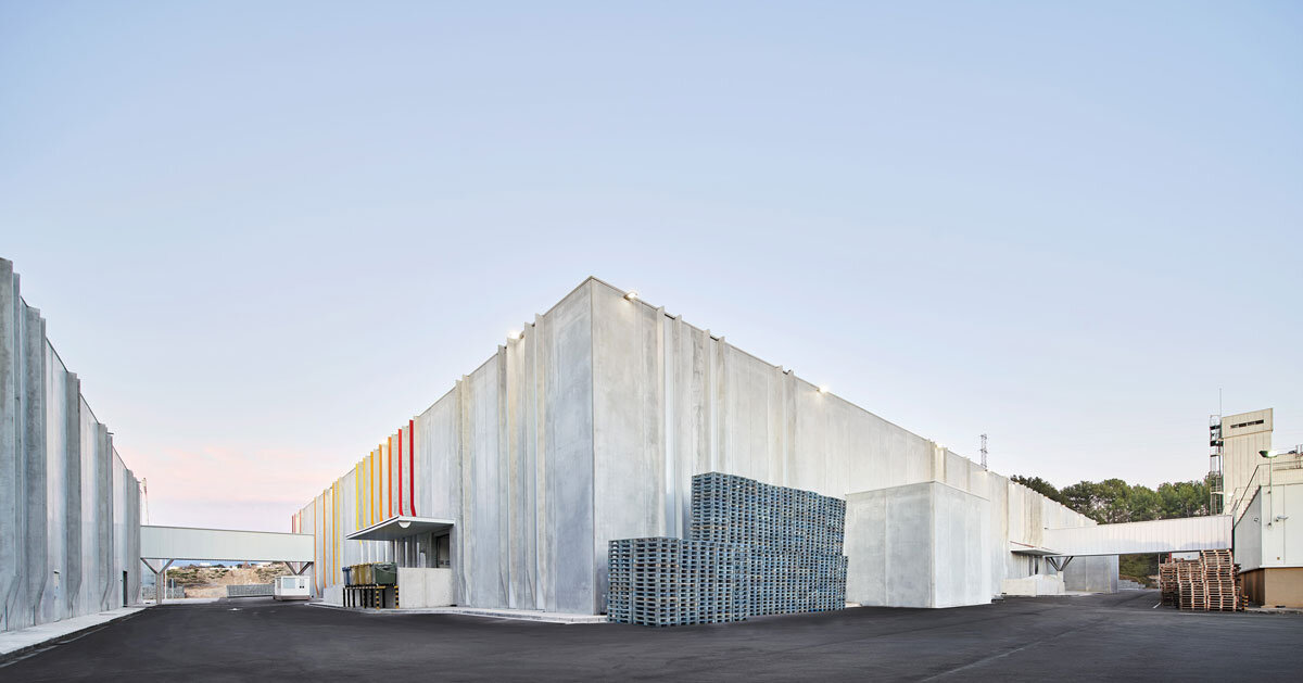 red and orange grooves brighten up factory’s concrete facade by ARQUID in barcelona