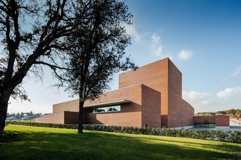 álvaro siza forms public auditorium in catalonia with monolithic red brick volumes