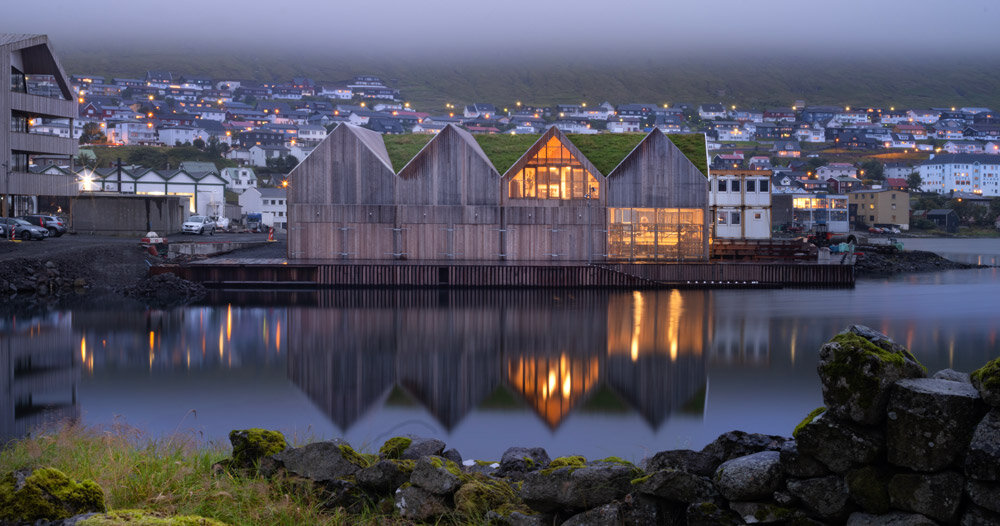 henning larsen's klaksvík row club backdropped by faroe islands' fjords