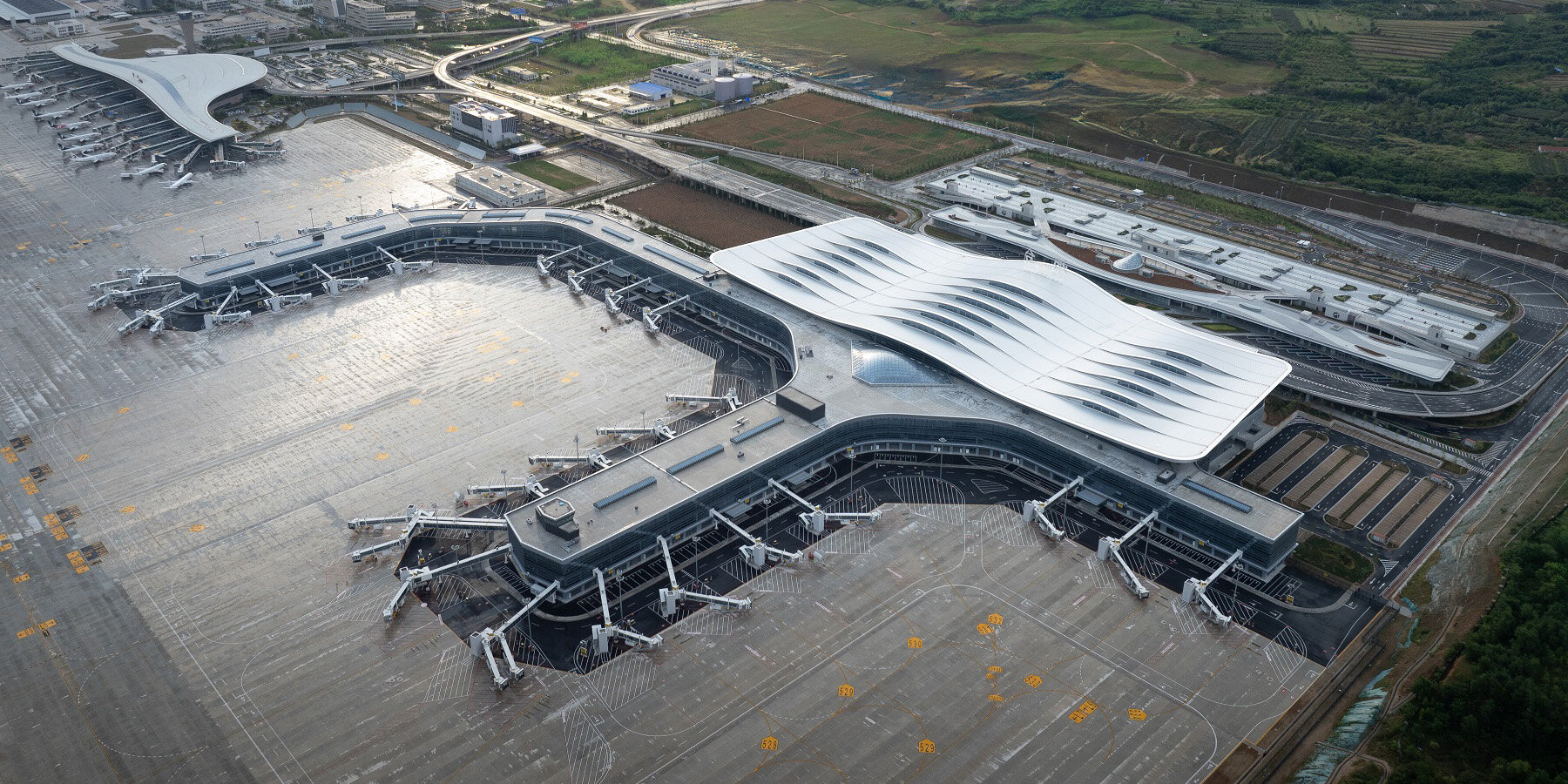 aedas' rippling terminal for yantai penglai airport echoes nearby mountains