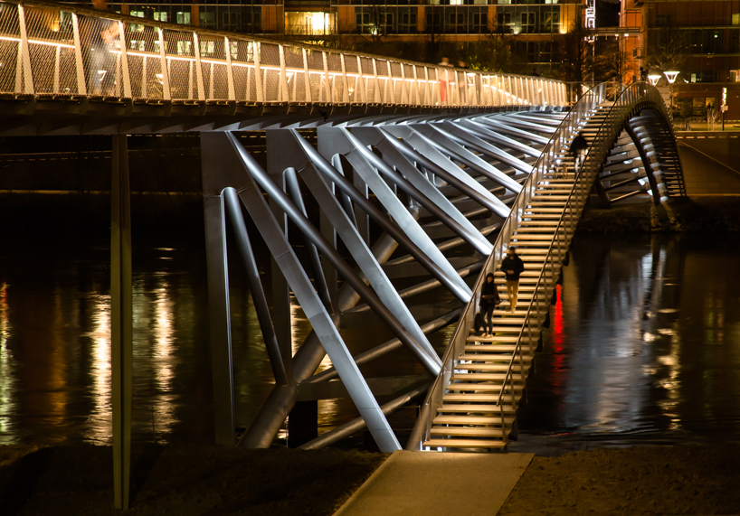 sleek concrete pedestrian bridge spans the vltava river in prague