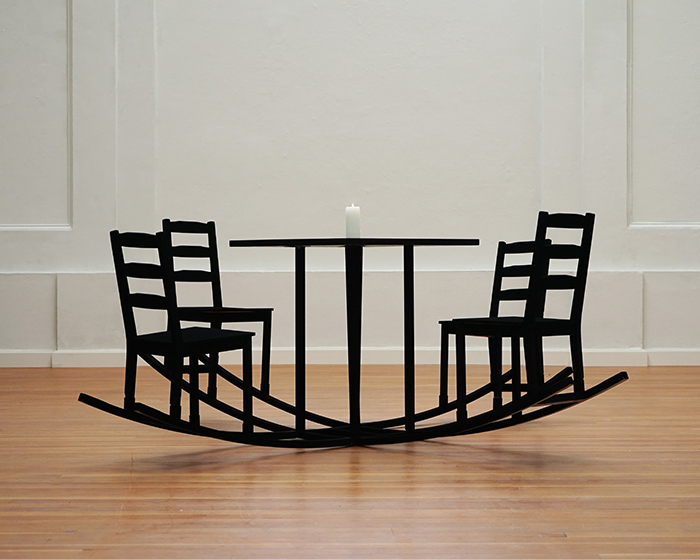 black furniture set is a seesaw-like sculpture that fosters bodily movement