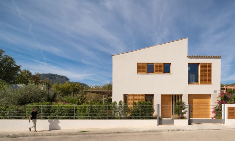 From below view of facade of modern green building with windows and panels  on wall on