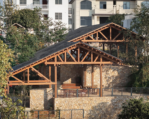 continuous gabled roof tops galaxy arch's wood-framed community space in chinese village