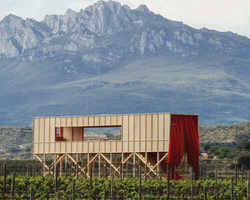 red curtains bridge the spanish vineyard with the domestic for pavilion at concéntrico