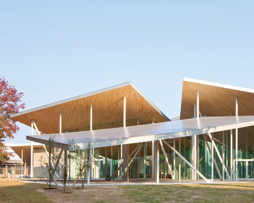 SANAA places junko fukutake hall beneath angled steel roof canopies