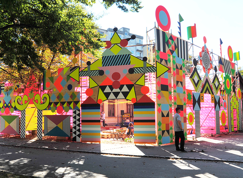 a scaffold structure hosts a blend of handmade signs, brightly colored ...