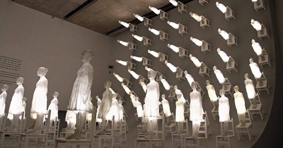 illuminated figures scale a ten-meter high wall in ataraxia by eugenio cuttica