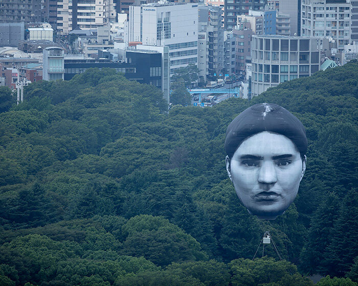 giant balloon head floats over tokyo