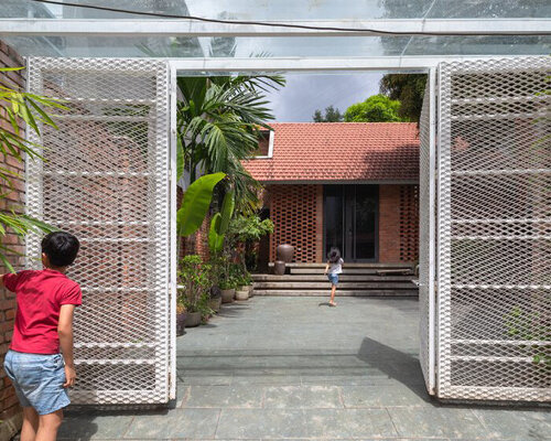 red bricks + rustic black stones clad this dwelling in the heart of vietnamese hillside