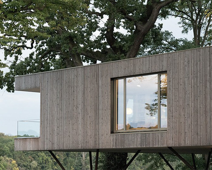 modern treehouse by carlos zwick perches above a lakeside in potsdam, germany