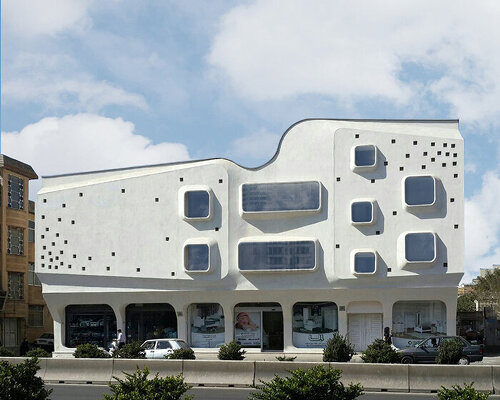 curved angles, extruded window frames + square dots characterize futuristic building in iran