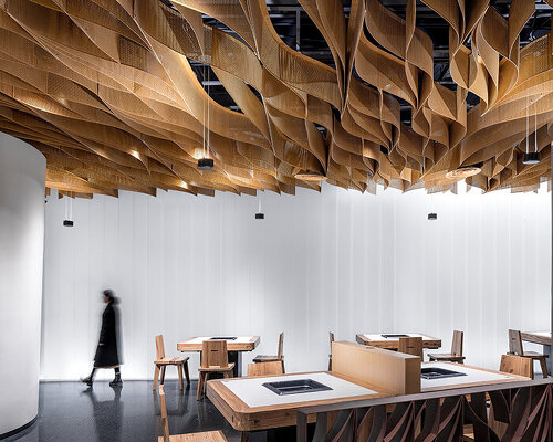 continuous undulating lattice ceiling hovers above banu restaurant in zhengzhou, china