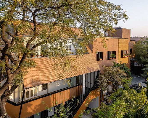 light-filled earthy colored home is cocooned in lush green garden in india