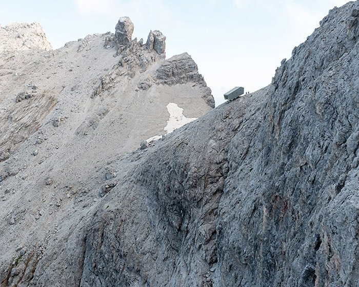 this rough-hewn inclined cabin is suspended on a cliff in the italian dolomites