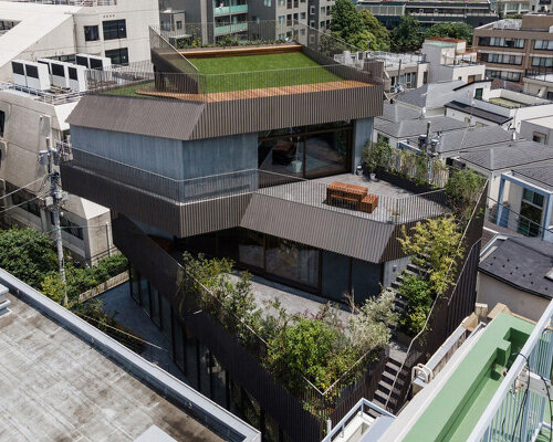 fortress-like residential building with irregular green terraces stands out in tokyo