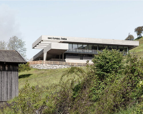 alleswirdgut's new community center in austria hovers over land as two suspended planes