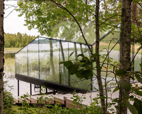 mirrored glass cabin with panoramic views disappears into finland's rich natural landscape