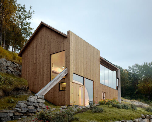 a slanted beam supports this fjord-side cabin in western norway