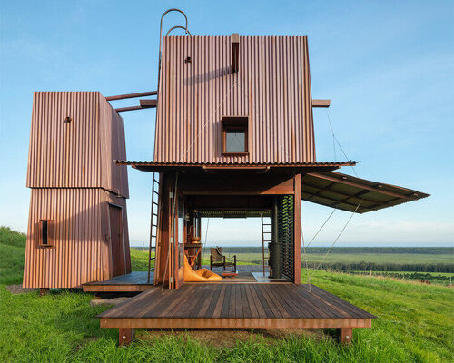 casey brown sets copper-clad cabin with movable awnings within lush australian paddocks