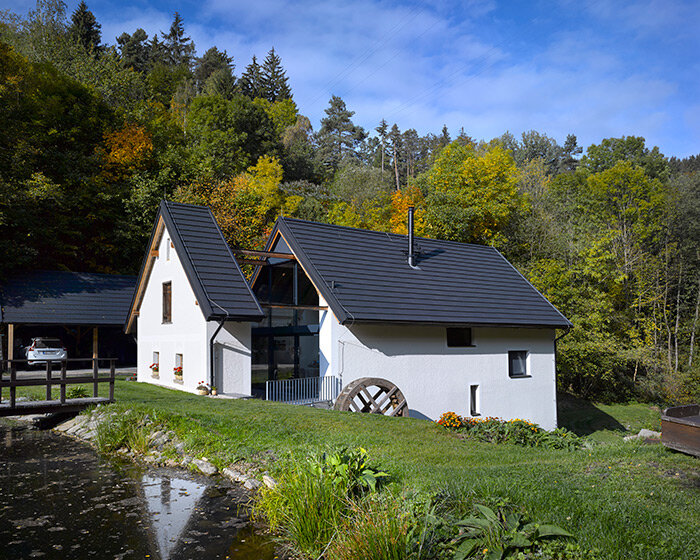 restored century-old mill splits into a home in czech republic's green ponds