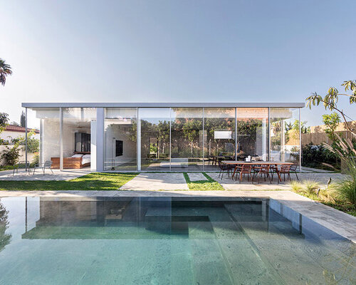 lush vegetation and an off-white concrete façade buffer this tel aviv house