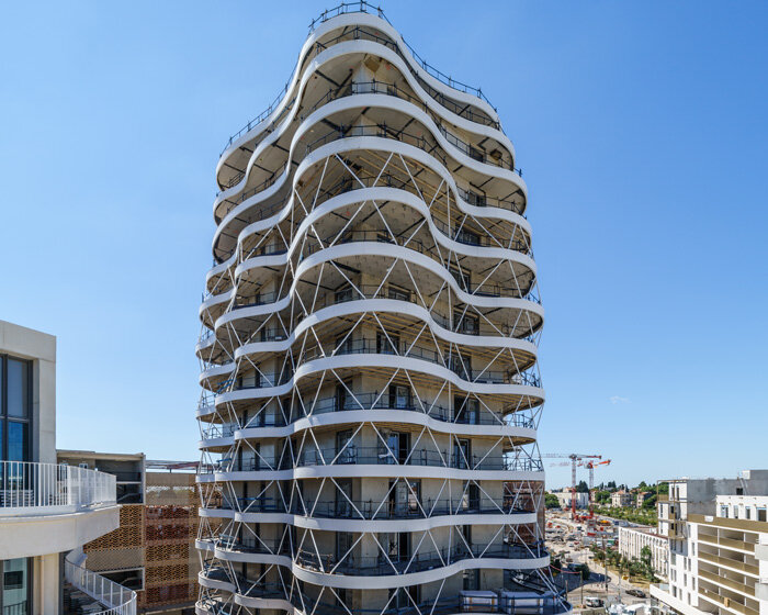 a housing tower with stacked and staggered undulating terraces takes shape in montpellier