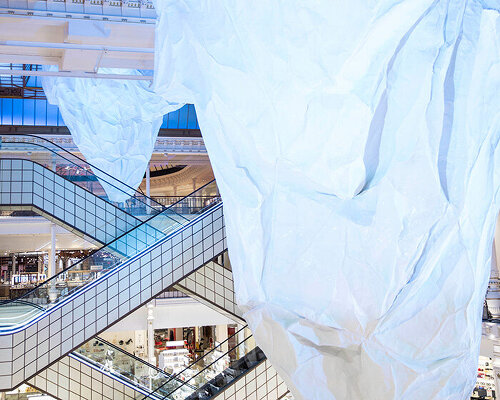 mehmet ali uysal hangs two massive icebergs at le bon marché in paris