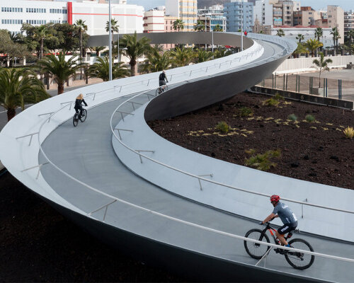 a 283-meter long footbridge warps and curves above city traffic in spain