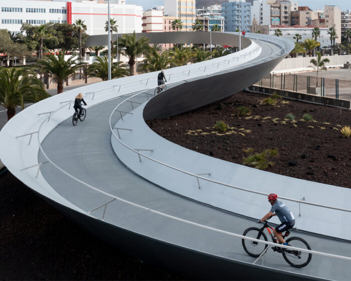 a 283-meter-long footbridge warps and curves above city traffic in spain