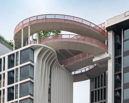 openbox architects inserts rose gold spiral ramp between two residential towers in bangkok