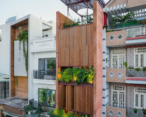 revolving wooden shutters clad the facade of AD9 architects' H house in vietnam