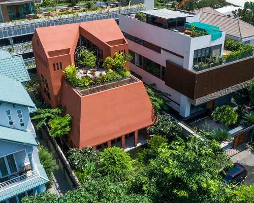 step inside the 'red cave' house, designed by 23o5studio as a garden retreat in vietnam