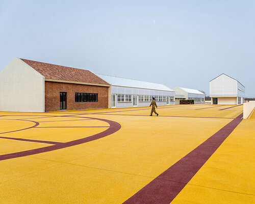 wutopia lab converts disused barnyard into golden yellow haven in shanghai