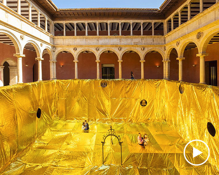 golden sheet made out of emergency blankets covers 16th-century convent patio in spain