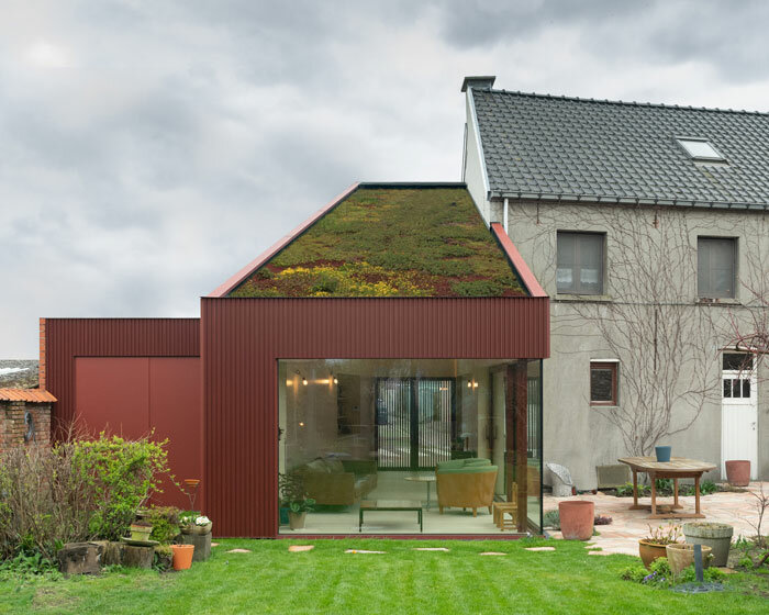 a green roof tops this red garden room extension in rural belgium