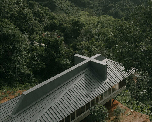 coffin-like chapel topped by giant cross hovers above a hill in mae sot, thailand