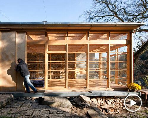 old stone walls show through the glass panes of a 'studio above the river' by martin rajniš