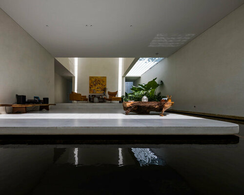 interior fish pond surrounds the living area of 23o5 studio's serene house in vietnam