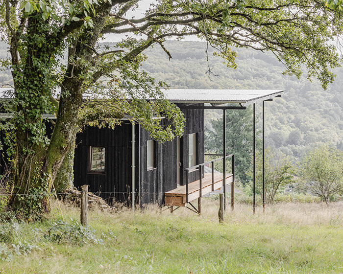 cantilevered wooden house by ciguë floats lightly above verdant field in france