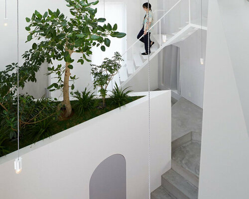 japanese residence by airhouse encloses minimalist interior of slanted floors and walls