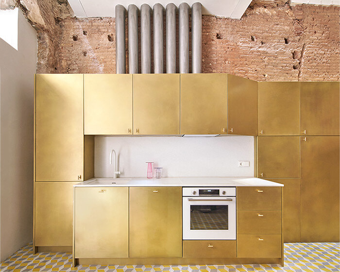 raúl sánchez adorns exposed brick interior with brass kitchen in renovated barcelona house