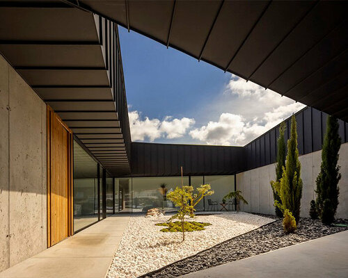 geometric central patio cuts through industrial concrete residence in portugal