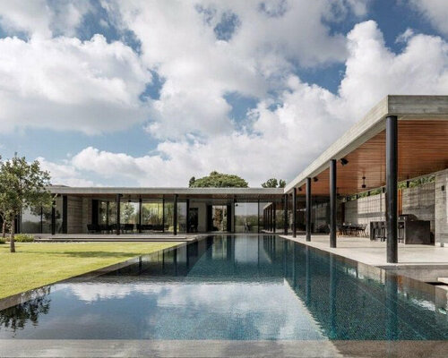 L-shaped home in israel opens up into a generous lush garden