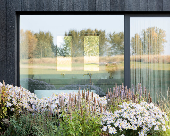 charred timber and nature surround JUMA's villa in the flemish ardennes