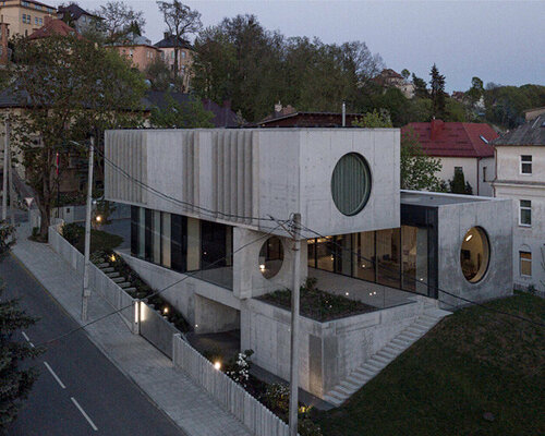 overlapping concrete volumes & circular windows complete modernist residence in lithuania