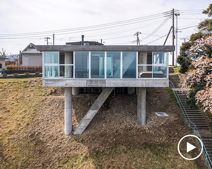 on a sloping terrain, massive concrete columns pierce noriaki hanaoka's house in japan