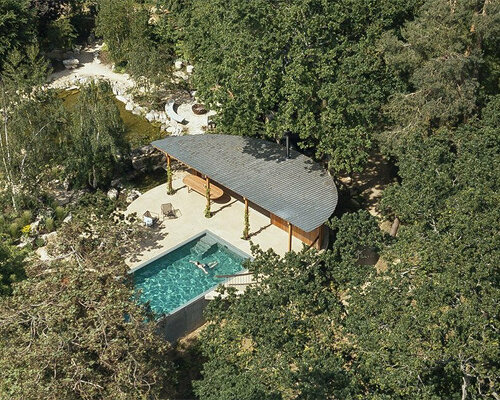 a poolhouse with precise geometries finds a home in this wild english garden