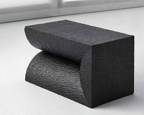 black monolithic furniture embraces organic semi-cylindrical forms + raw wood log textures